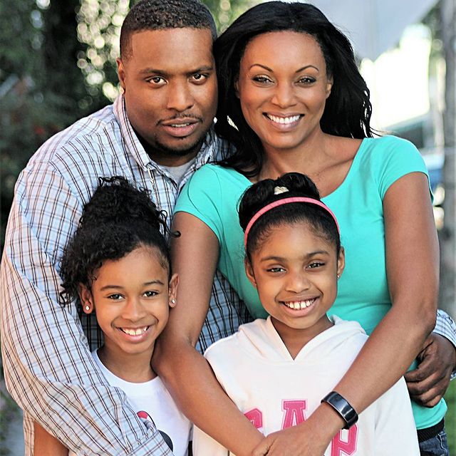 Brianni Walker in a white hoodie with her parents in a shirt and green t-shirt.